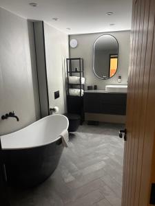a bathroom with a tub and a sink and a mirror at Raasay Apartment in Fort William