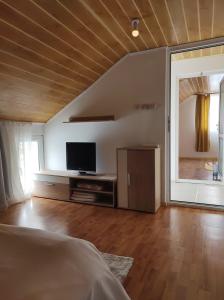 a living room with a tv and a large window at casa Olga 2 Mai in 2 Mai