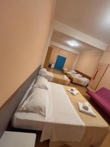 a hospital room with three beds and a blue door at Campus Baia Serena in Bellaria-Igea Marina