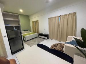 a living room with two beds and a couch at Studio Inap Seri Iskandar in Kampong Bota Road