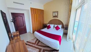 a bedroom with a large bed with red pillows at Luxury Skyline Apartment with Panoramic Views in Sharjah