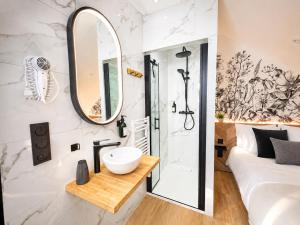 a bathroom with a white sink and a mirror at MRODBNB - Maisonnette Atypique enfouie dans la Roche - Gr34, Plage, Resto & Huîtres à 25m in Cancale