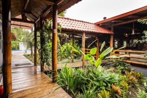 a wooden deck with plants and a building at La Bicok EcoLodge in Mindo