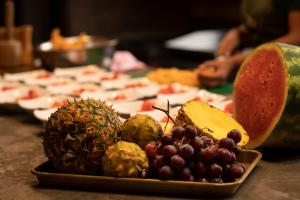a plate of fruit on a table with a pizza at La Bicok EcoLodge in Mindo