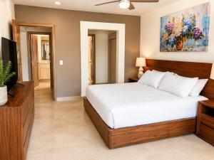 a bedroom with a bed and a painting on the wall at Luxury Beachfront Condo at Krystal Grand Resort - NEWLY REMODELED & NEWLY FURNISHED in Bucerías +22 photos