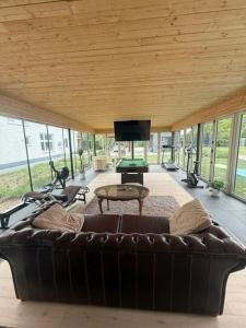 a living room with a leather couch and a flat screen tv at Berckenhof in Heusden - Zolder