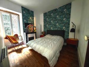 a bedroom with a bed and a chair in it at Chez Mina in Saint-Béat