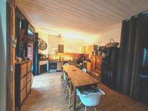 a kitchen with a wooden table and chairs in it at Chez Mina in Saint-Béat