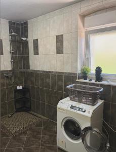 a washing machine in a bathroom with a shower at Villa with stunning Mountain Views and Authentic Croatian Stone House near Split and Sea in Žrnovnica