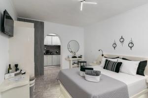a white bedroom with a bed and a living room at Miloessa in Adamantas