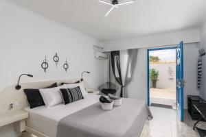 a white bedroom with a bed and a sliding glass door at Miloessa in Adamantas