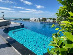 a swimming pool with blue tiles on a building at The Patio Bangsaen Cozy Condo in Chon Buri
