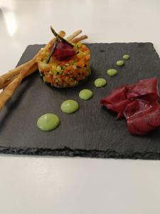 a black plate with some food on it at Albergo Santa Maria in Esino Lario