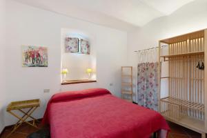 a bedroom with a bed with a red blanket at Casa Lena in Arma di Taggia