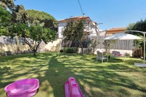 a backyard with pink inflatables in the grass at Casa Lena in Arma di Taggia