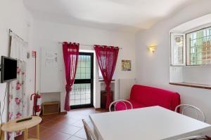 a living room with a red couch and a window at Casa Lena in Arma di Taggia