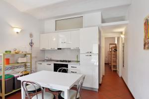 a kitchen with white cabinets and a white table at Casa Lena in Arma di Taggia