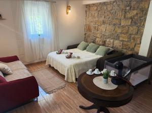 a living room with a bed and a table at Villa with stunning Mountain Views and Authentic Croatian Stone House near Split and Sea in Žrnovnica +29 photos