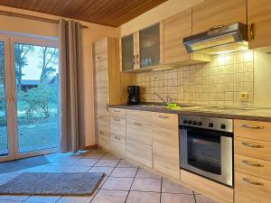 a kitchen with wooden cabinets and a stove top oven at Ferienhof Tödter in Schneverdingen