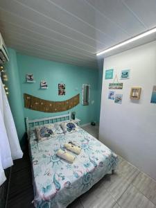 a bedroom with a bed and a wall with pictures at Suíte Maresia - Pousada Castelo do Luar in Penha