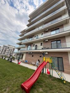 a playground with a slide in front of a building at Alemar Mamaia Nord in Năvodari