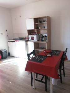 a room with a table and a kitchen with a microwave at Marina & Alex in Château-Gaillard
