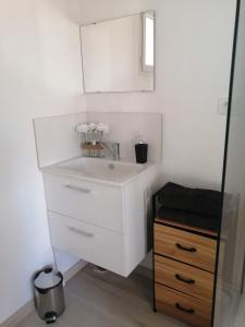 a bathroom with a white sink and a wooden cabinet at Marina & Alex in Château-Gaillard