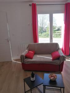 a living room with a couch with two red pillows at Marina & Alex in Château-Gaillard