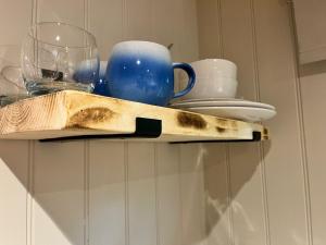 a shelf with a knife and glasses on it at Half Moon Shepherds Huts in Plumpton +4 photos