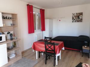 a room with a table and a bed with a red curtain at Marina & Alex in Château-Gaillard