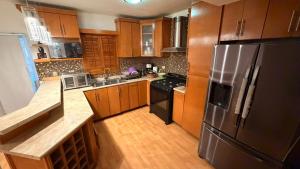 a kitchen with wooden cabinets and a stainless steel refrigerator at Casa San Carlos in La Coyotera