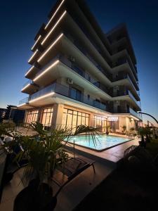 a large building with a swimming pool in front of it at Alemar Mamaia Nord in Năvodari