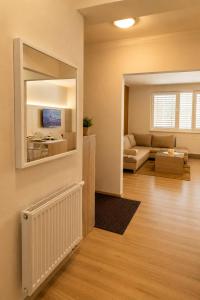 a living room with a couch and a tv on a wall at Apartman Pred polom in Trenčín