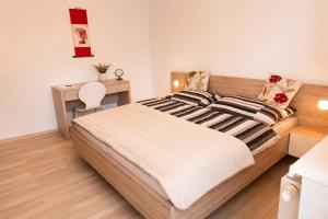 a bedroom with a bed with a desk and a table at Apartman Pred polom in Trenčín