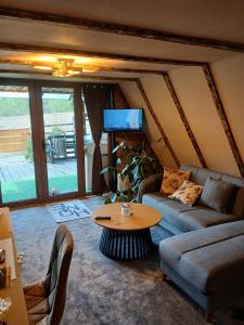 a living room with a couch and a table at Maria's Cabin & Spa in Băiaşu