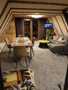 a living room with a table and a couch at Maria's Cabin & Spa in Băiaşu