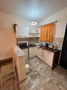 a kitchen with white cabinets and a counter top at Biscoutsis Apartments & Studios in Kavos