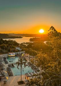 a view of a pool at a resort at sunset at Grand Suítes Family Resort in Itá