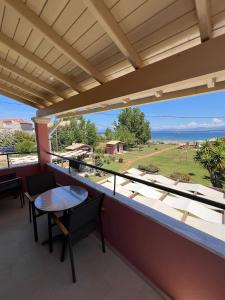 a balcony with a table and a view of the ocean at Biscoutsis Apartments & Studios in Kavos