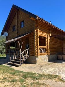 a log cabin with a porch and stairs to it at Думанія in Verkhovyna +19 photos