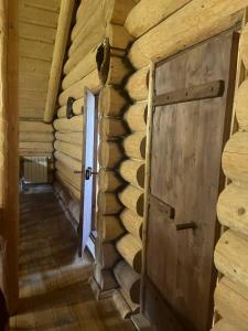 an empty room with a door in a log cabin at Думанія in Verkhovyna