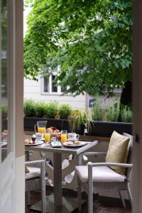 ein Tisch mit Speisen und Getränken auf einer Terrasse in der Unterkunft Hotel Augusta Am Kurfürstendamm in Berlin