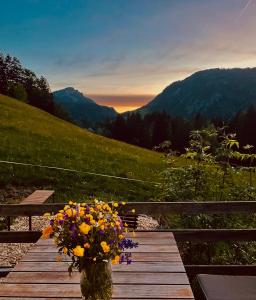 a vase filled with flowers sitting on a wooden table at Chalet Alpenlicht in Oberstdorf