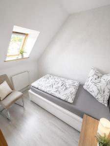 a small bedroom with a bed and a chair at Ferienwohnung Rita Usedom in Korswandt