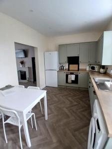 a kitchen with a white table and white appliances at Hilltop Retreat at Banktop in Southowram