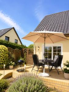 a patio with a table and chairs and an umbrella at Ferienwohnung Rita Usedom in Korswandt