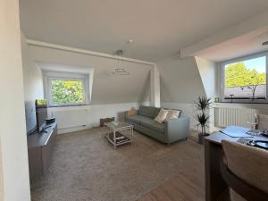 ein Wohnzimmer mit Sofa und Fernseher in der Unterkunft Falltor Living in Rees