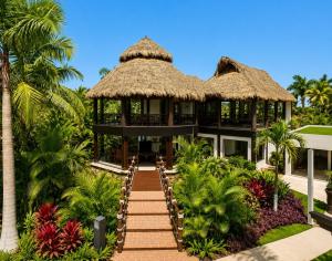 a resort building with a thatched roof at Luxury Beachfront Condo at Krystal Grand Resort - NEWLY REMODELED & NEWLY FURNISHED in Bucerías