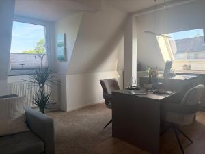 ein Wohnzimmer mit Schreibtisch, Stühlen und Fenster in der Unterkunft Falltor Living in Rees