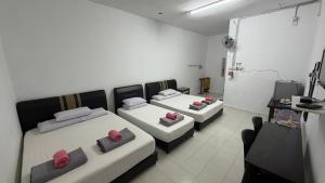 a room with two beds and a television in it at Bunga Raya Guest House BALING in Baling